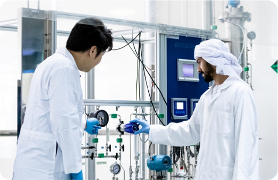 Two researchers in a lab with complex machinery.