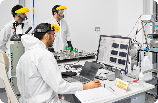 Researchers working with computers and equipment in a lab.